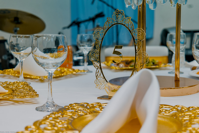 Crystal glasses and a gold-framed mirror on a set banquet table