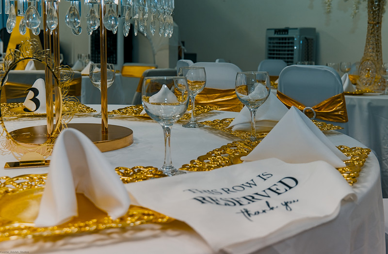 A reserved card and gold charger plates on a set table