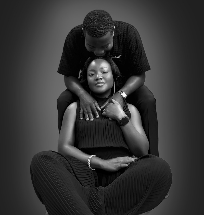 Black and white portrait of the groom behind his seated bride